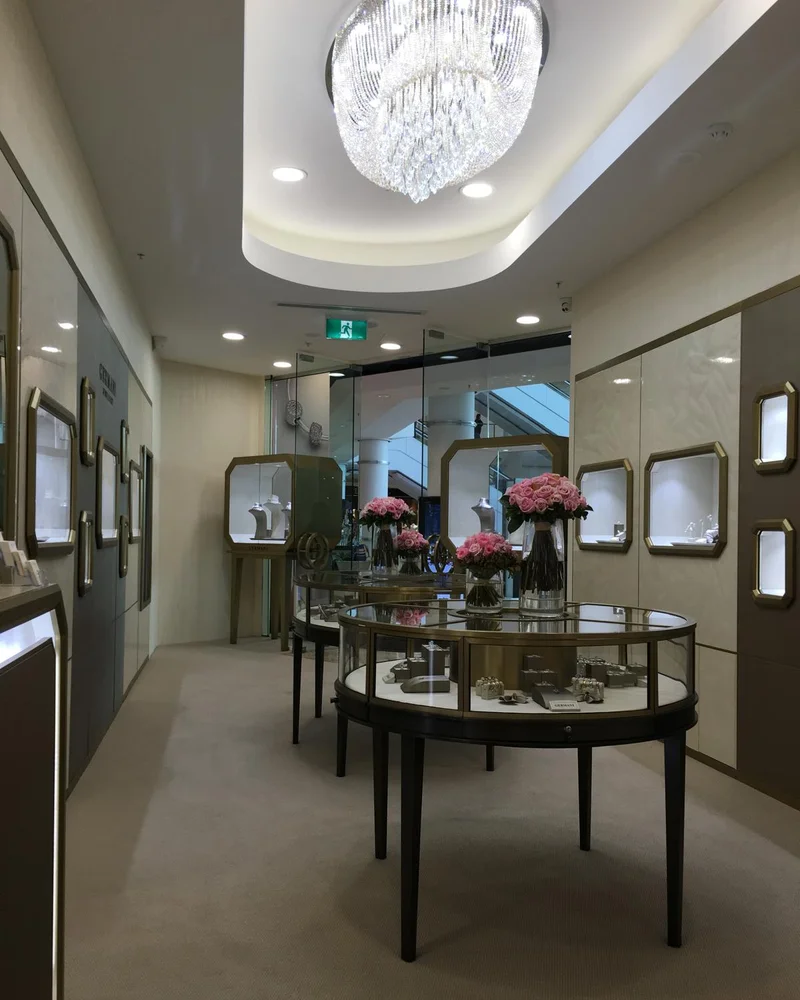 A fitted Germani boutique with a crystal chandelier, round showcases and pink roses