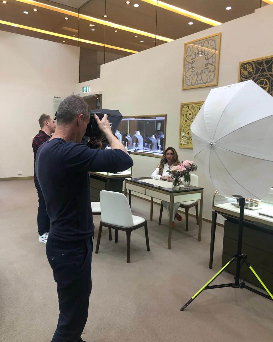 Photographer shooting a model seated at a Germani consultation table