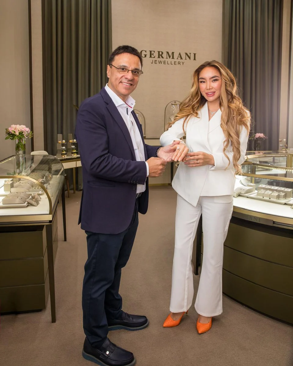 Michel Germani placing a ring on a model in the Germani showroom